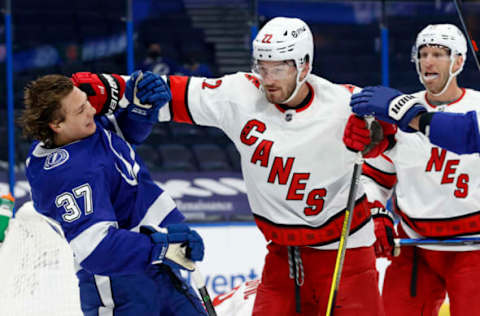 Feb 24, 2021; Tampa, Florida, USA; Carolina Hurricanes defenseman Brett Pesce (22) and Tampa Bay Lightning center Yanni Gourde (37) push each other during the first period at Amalie Arena. Mandatory Credit: Kim Klement-USA TODAY Sports