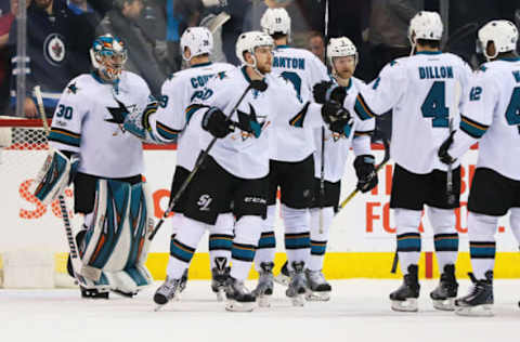 NHL Power Rankings: San Jose Sharks goalie Aaron Dell (30) celebrates with teammates after defeating the Winnipeg Jets 4-3 at MTS Centre. Mandatory Credit: Bruce Fedyck-USA TODAY Sports