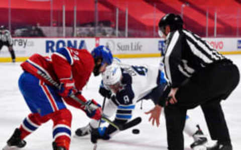 Apr 30, 2021; Montreal, Quebec, CAN; Linesman Travis Toomey (90) drops the puck for a faceoff between Montreal Canadiens forward Phillip Danault (24) and Winnipeg Jets forward Andrew Copp (9) during the first period at the Bell Centre. Mandatory Credit: Eric Bolte-USA TODAY Sports