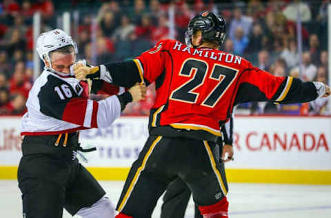 Oct 5, 2016; Calgary, Alberta, CAN; Arizona Coyotes left wing Max Domi (16) and Calgary Flames defenseman Dougie Hamilton (27) fight during the first period during a preseason hockey game at Scotiabank Saddledome. Mandatory Credit: Sergei Belski-USA TODAY Sports