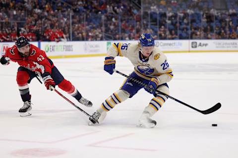 Mar 25, 2022; Buffalo, New York, USA; Washington Capitals right wing Tom Wilson (43) tries to defend as Buffalo Sabres defenseman Rasmus Dahlin (26) skates with the puck during the third period at KeyBank Center. Mandatory Credit: Timothy T. Ludwig-USA TODAY Sports