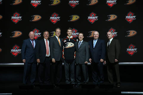 Shea Theodore poses for a photo with Anaheim Ducks team personnel (Photo by Bruce Bennett/Getty Images)