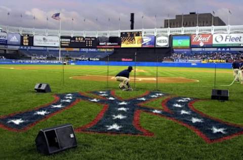 NEW YORK, UNITED STATES: Groundskeepers prepare the field near a new patriotically-colored New York Yankees logo before the Yankees played the Tampa Bay Devil Rays 25 September 2001 at Yankee Stadium in The Bronx, New York, NY. The game was the first played at Yankee Stadium since the terrorist attacks on the World Trade Cetner 11 September 2001. AFP PHOTO/Matt CAMPBELL (Photo credit should read MATT CAMPBELL/AFP via Getty Images)