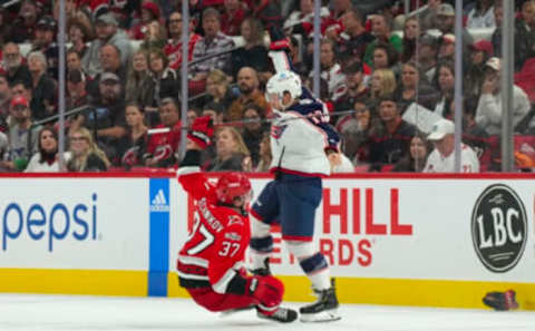 Oct 12, 2022; Raleigh, North Carolina, USA; Columbus Blue Jackets right wing Justin Danforth (17) checks Carolina Hurricanes right wing Andrei Svechnikov (37) during the second period at PNC Arena. Mandatory Credit: James Guillory-USA TODAY Sports