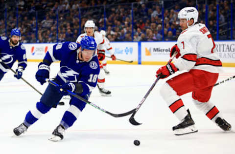 TAMPA, FLORIDA – OCTOBER 01: Ondrej Palat #18 of the Tampa Bay Lightning and Brendan Smith #7 of the Carolina Hurricanes fights for the puck during a preseason game at Amalie Arena on October 01, 2021, in Tampa, Florida. (Photo by Mike Ehrmann/Getty Images)