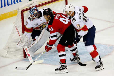 NEWARK, NJ – OCTOBER 27: Goaltender James Reimer #34 and teammate Michael Matheson #19 of the Florida Panthers defend the net against Miles Wood #44 of the New Jersey Devils at the Prudential Center on October 27, 2018 in Newark, New Jersey. (Photo by Eliot J. Schechter/NHLI via Getty Images)