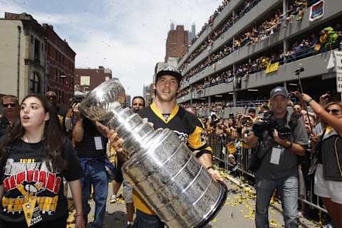 Jun 15, 2016; Pittsburgh, PA, USA; Fans look on from a parking garage as Pittsburgh Penguins defenseman Kris Letang (58) carries the cup during the Stanley Cup championship parade and celebration in downtown Pittsburgh. Mandatory Credit: Charles LeClaire-USA TODAY Sports