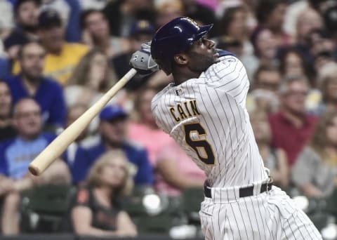 Aug 7, 2021; Milwaukee, Wisconsin, USA; Milwaukee Brewers center fielder Lorenzo Cain (6) hits a sacrifice fly to drive in a run in the fourth inning against the San Francisco Giants at American Family Field. Mandatory Credit: Benny Sieu-USA TODAY Sports