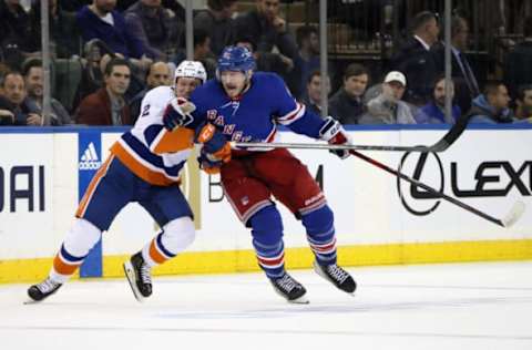 NEW YORK, NEW YORK – DECEMBER 22: Robin Salo #2 of the New York Islanders slows down Julien Gauthier #12 of the New York Rangers during the second period at Madison Square Garden on December 22, 2022, in New York City. (Photo by Bruce Bennett/Getty Images)