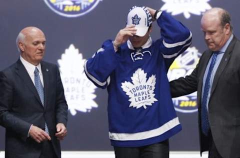 Jun 24, 2016; Buffalo, NY, USA; Auston Matthews puts on a team cap after being selected as the number one overall draft pick by the Toronto Maple Leafs in the first round of the 2016 NHL Draft at the First Niagra Center. Mandatory Credit: Timothy T. Ludwig-USA TODAY Sports