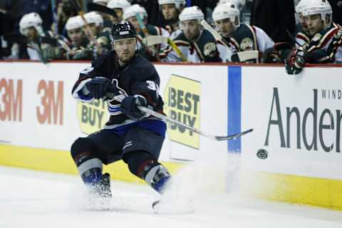 Brad May #32 of the Vancouver Canucks dumps the puck in (Photo by Elsa/Getty Images/NHL)