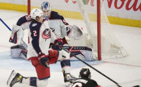 Mar 16, 2022; Ottawa, Ontario, CAN; Columbus Blue Jackets defenseman Andrew Peeke (2) blocks a shot from Ottawa Senators defenseman Erik Brannstrom (26) in the third period at the Canadian Tire Centre. Mandatory Credit: Marc DesRosiers-USA TODAY Sports