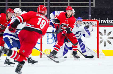 Feb 22, 2021; Raleigh, North Carolina, USA; Carolina Hurricanes right wing Sebastian Aho (20) and Tampa Bay Lightning goaltender Andrei Vasilevskiy (88) watch the shot during the third period at PNC Arena. Mandatory Credit: James Guillory-USA TODAY Sports