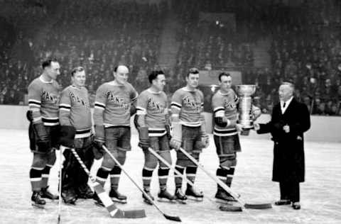 UNITED STATES – NOVEMBER 17: The Rangers, champs last year, receive their award. President Frank Calder of the National Hockey League presents the Stanley Cup to (l. to r.): Seibert, Aitkenhead, Johnson, Boucher, Bun Cook and his brother, Capt. Bill Cook. (Photo by NY Daily News Archive via Getty Images)