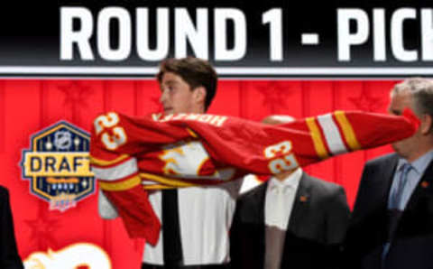 Jun 28, 2023; Nashville, Tennessee, USA; Calgary Flames draft pick Samuel Honzek puts on his sweater after being selected with the sixteenth pick in round one of the 2023 NHL Draft at Bridgestone Arena. Mandatory Credit: Christopher Hanewinckel-USA TODAY Sports