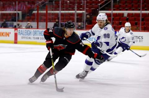 RALEIGH, NORTH CAROLINA – JANUARY 28: Jake Bean skates with the puck against Mikhail Sergachev #98 of the Tampa Bay Lightning during the first period of their game at PNC Arena on January 28, 2021 in Raleigh, North Carolina. (Photo by Jared C. Tilton/Getty Images)