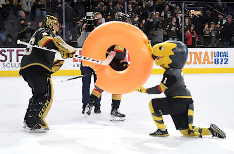 LAS VEGAS, NEVADA – FEBRUARY 26: Marc-Andre Fleury #29 of the Vegas Golden Knights takes an inflatable doughnut, signifying a shutout win, from the Golden Knights mascot Chance the Golden Gila Monster after the team’s 3-0 victory over the Edmonton Oilers at T-Mobile Arena on February 26, 2020 in Las Vegas, Nevada. Fleury recorded his 61st career shutout tying Turk Broda for 17th all-time. (Photo by Ethan Miller/Getty Images)