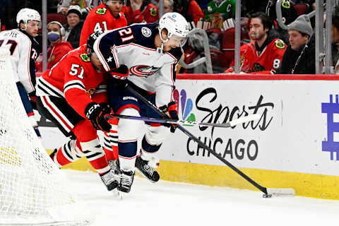 Dec 23, 2022; Chicago, Illinois, USA; Chicago Blackhawks defenseman Ian Mitchell (51) and Columbus Blue Jackets center Josh Dunne (21) move the puck during the first period at the United Center. Mandatory Credit: Matt Marton-USA TODAY Sports