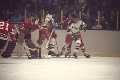 German ice hockey player Walt Tkaczuk (#18) and Canadian Bill Fairbairn of the New York Rangers scrabble behind the net with Doug Jarrett of the Chicago Blackhawks during a game, early 1970s. Jarrett’s teammates Czech player Stan Mitika (#21) and goalkeeper Gary Smith watch from in front of the net. (Photo by Melchior DiGiacomo/Getty Images)