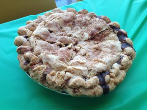 An apple pie on a teal tablecloth.