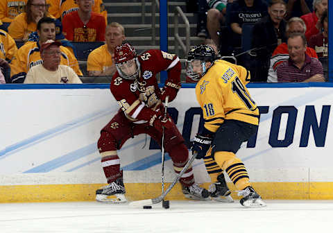 Apr 7, 2016; Tampa, FL, USA; Boston College Eagles forward Austin Cangelosi (26) and Quinnipiac Bobcats forward Soren Jonzzon (18) fight to control the puck during the first period of the semifinals of the 2016 Frozen Four college ice hockey tournament at Amalie Arena. Mandatory Credit: Kim Klement-USA TODAY Sports