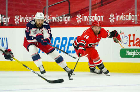 Feb 15, 2021; Raleigh, North Carolina, USA; Carolina Hurricanes left wing Jordan Martinook (48) tries to control the puck against Columbus Blue Jackets left wing Nick Foligno (71) during the second period at PNC Arena. Mandatory Credit: James Guillory-USA TODAY Sports