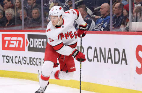 WINNIPEG, MB – DECEMBER 17: Brett Pesce #22 of the Carolina Hurricanes plays the puck along the boards during first period action against the Winnipeg Jets at the Bell MTS Place on December 17, 2019 in Winnipeg, Manitoba, Canada. The Canes defeated the Jets 6-3. (Photo by Darcy Finley/NHLI via Getty Images)