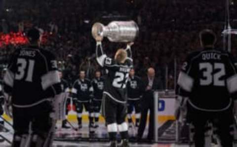 Oct 8, 2014; Los Angeles, CA, USA; Los Angeles Kings right wing Dustin Brown (23) hoists the Stanley Cup as the Los Angeles Kings are introduced as the 2013-2014 Stanley Cup Champions prior to the game between the San Jose Sharks and Los Angeles Kings at Staples Center. Mandatory Credit: Kelvin Kuo-USA TODAY Sports