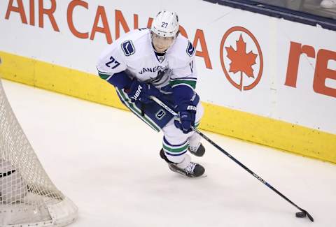 Nov 14, 2015; Toronto, Ontario, CAN; Vancouver Canucks defenseman Ben Hutton (27) skates around his net with the puck against the Toronto Maple Leafs at Air Canada Centre. The Maple Leafs beat the Canucks 4-2. Mandatory Credit: Tom Szczerbowski-USA TODAY Sports