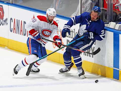 Tomas Tatar #90 of the Montreal Canadiens battles against Justin Holl #3 of the Toronto Maple Leafs  (Photo by Claus Andersen/Getty Images)