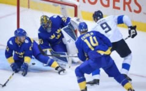 Sep 20, 2016; Toronto, Ontario, Canada; Team Sweden goalie Henrik Lundqvist (30) makes a save on Team Finland forward Mikko Koivu (9) as defencemen Niklas Hjalmarsson (4) and Mattias Ekholm (14) look for the rebound during preliminary round play in the 2016 World Cup of Hockey at Air Canada Centre. Mandatory Credit: Dan Hamilton-USA TODAY Sports