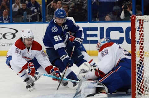 Mar 31, 2016; Tampa, FL, USA; Tampa Bay Lightning center Steven Stamkos (91) shoots the puck against Montreal Canadiens center David Desharnais (51) and goalie Mike Condon (39) during the second period at Amalie Arena. Mandatory Credit: Kim Klement-USA TODAY Sports