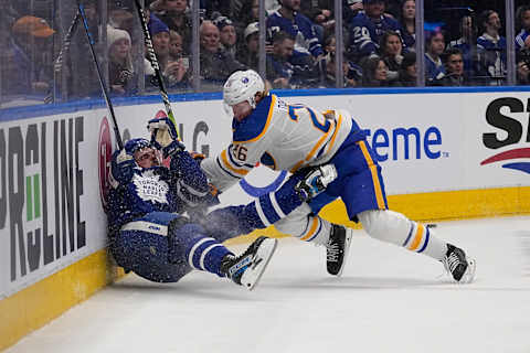 Mar 13, 2023; Toronto, Ontario, CAN; Buffalo Sabres defenseman Rasmus Dahlin (26) hits Toronto Maple Leafs forward Auston Matthews (34) into the boards during the first period at Scotiabank Arena. Mandatory Credit: John E. Sokolowski-USA TODAY Sports