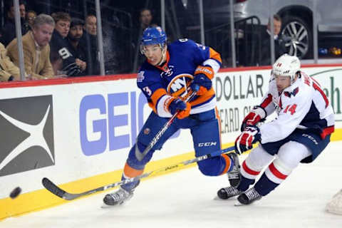 Feb 18, 2016; Brooklyn, NY, USA; New York Islanders defenseman Travis Hamonic (3) passes the puck against Washington Capitals right wing Justin Williams (14) during the third period at Barclays Center. The Capitals defeated the Islanders 3-2 in overtime. Mandatory Credit: Brad Penner-USA TODAY Sports