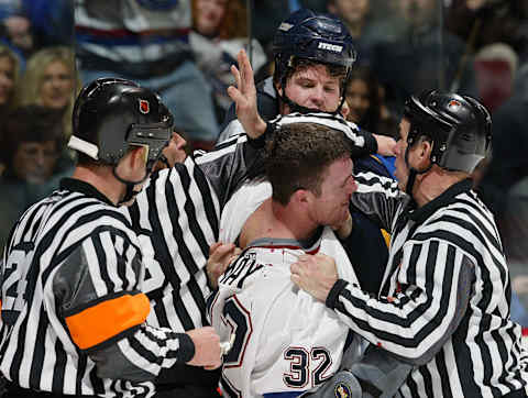 VANCOUVER, CANADA – MARCH 13: Referees try to separate Brad May #32 of the Vancouver Canucks and Reed Lowe #34 of the St. Louis Blues as they fight during the first period of their NHL game at General Motors Place on March 13, 2003, in Vancouver, Canada. Lowe instigated a fight with May after May checked Keith Tkachuk, injuring Tkachuk’s wrist. (Photo by Jeff Vinnick/Getty Images/NHLI)