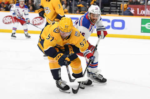 Dec 2, 2023; Nashville, Tennessee, USA; Nashville Predators defenseman Dante Fabbro (57) plays the puck away from New York Rangers center Vincent Trocheck (16) during the second period at Bridgestone Arena. Mandatory Credit: Christopher Hanewinckel-USA TODAY Sports