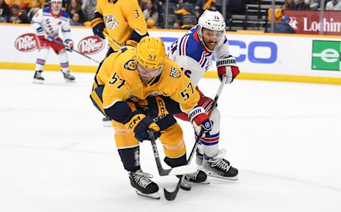 Dec 2, 2023; Nashville, Tennessee, USA; Nashville Predators defenseman Dante Fabbro (57) plays the puck away from New York Rangers center Vincent Trocheck (16) during the second period at Bridgestone Arena. Mandatory Credit: Christopher Hanewinckel-USA TODAY Sports