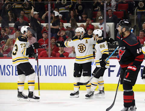 RALEIGH, NORTH CAROLINA – MAY 16: Patrice Bergeron #37 of the Boston Bruins celebrates with David Pastrnak #88 and Charlie McAvoy #73 after scoring a goal on Curtis McElhinney #35 of the Carolina Hurricanes during the third period in Game Four of the Eastern Conference Finals during the 2019 NHL Stanley Cup Playoffs at PNC Arena on May 16, 2019 in Raleigh, North Carolina. (Photo by Bruce Bennett/Getty Images)