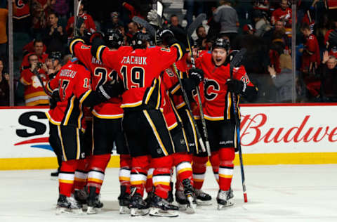 CALGARY, AB – FEBRUARY 3: Matthew Tkachuk #19, Curtis Lazar #20 and teammates of the Calgary Flames celebrate a overtime goal against the Chicago Blackhawks during an NHL game on February 3, 2018 at the Scotiabank Saddledome in Calgary, Alberta, Canada. (Photo by Gerry Thomas/NHLI via Getty Images)