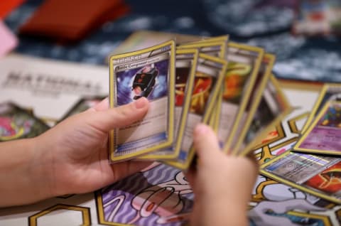 Hands shuffle Pokémon cards at a tournament