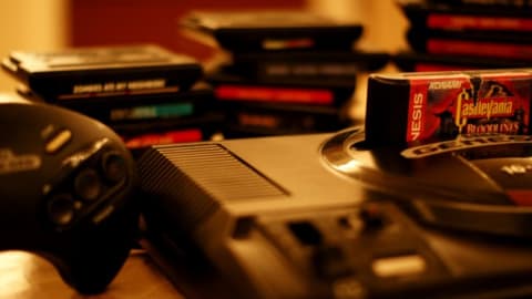 A 'Castlevania' game in a Sega Genesis console on a table with other games