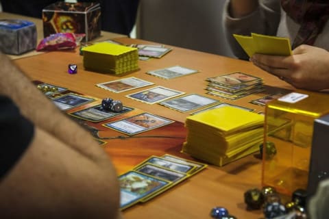 Players at a table playing Magic: The Gathering