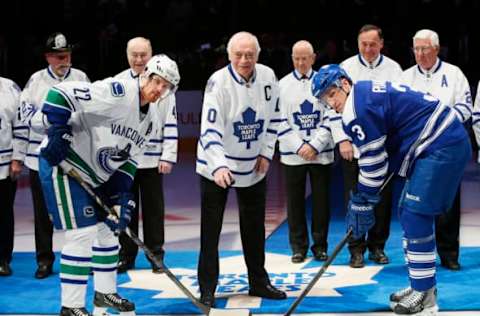 Feb 8, 2014; Toronto, Ontario, CAN; Former Toronto Maple Leafs captain George Armstrong drops the puck to Vancouver Canucks forward Daniel Sedin (22) and Toronto Maple Leafs defenseman Dion Phaneuf (3) as Eddie Shack and Red Kelly ad Dave Keon and Frank Mahovlich and Bob Pulford (left to right) look on during the first period at the Air Canada Centre. Mandatory Credit: John E. Sokolowski-USA TODAY Sports