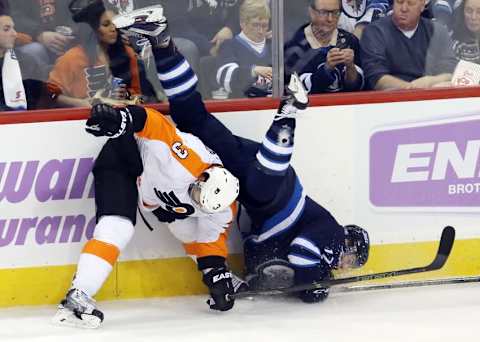 Nov 7, 2015; Winnipeg, Manitoba, CAN; Winnipeg Jets left wing Adam Lowry (17) is hit by Philadelphia Flyers defenseman Radko Gudas (3) during the second period at MTS Centre. Mandatory Credit: Bruce Fedyck-USA TODAY Sports