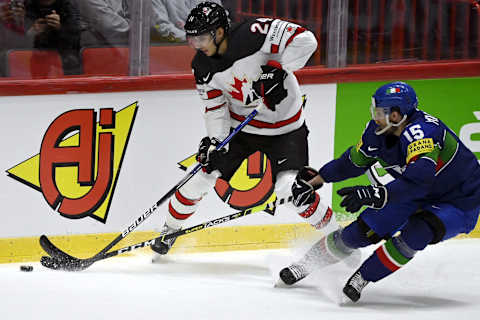 Canada’s forward Dylan Cozens (L) and Italy’s defender Enrico Miglioranzi vie for the puck during the 2022 IIHF Ice Hockey World Championships preliminary round group A match between Italy and Canada in Helsinki on May 15, 2022. – – Finland OUT (Photo by Antti Aimo-Koivisto / Lehtikuva / AFP) / Finland OUT (Photo by ANTTI AIMO-KOIVISTO/Lehtikuva/AFP via Getty Images)