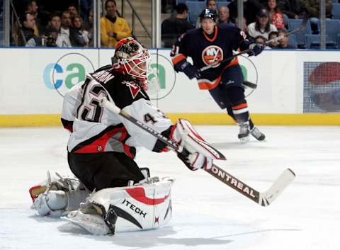 UNIONDALE, NY – NOVEMBER 23: Goaltender Martin Biron #43 of the Buffalo Sabres makes a save as Robert Nilsson #21 of the New York Islanders moves in on November 23, 2005 at Nassau Coliseum in Uniondale, New York. The Sabres defeated the Islanders 4-3 in a shootout. (Photo by Jim McIsaac/Getty Images)