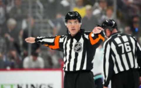 Apr 30, 2023; Denver, Colorado, USA; NHL referee Chris Rooney (5) calls a reversal of a goal by Colorado Avalanche center Nathan MacKinnon (29) (not pictured) in the third period against the Seattle Kraken in game seven of the first round of the 2023 Stanley Cup Playoffs at Ball Arena. Mandatory Credit: Ron Chenoy-USA TODAY Sports