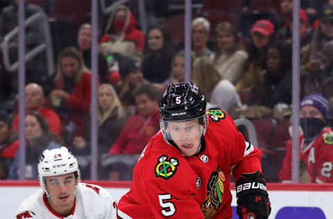 CHICAGO, ILLINOIS – NOVEMBER 03: Connor Murphy #5 of the Chicago Blackhawks skates against Seth Jarvis #24 of the Carolina Hurricanes during the first period at United Center on November 03, 2021, in Chicago, Illinois. (Photo by Stacy Revere/Getty Images)