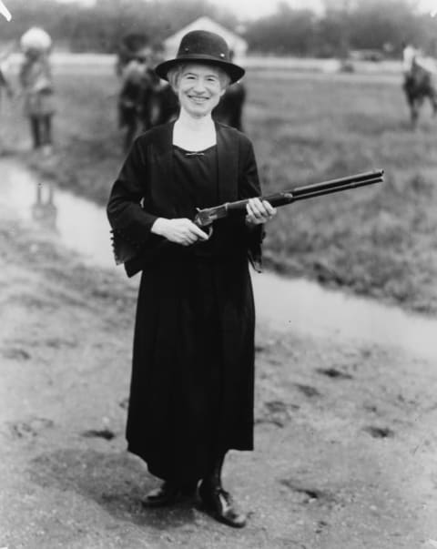 A 1922 photo of Annie Oakley holding a gun given to her by Buffalo Bill.