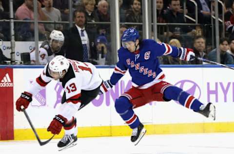 NEW YORK, NEW YORK – NOVEMBER 28: Nico Hischier #13 of the New Jersey Devils sidesteps a check from Jacob Trouba #8 of the New York Rangers during the first period at Madison Square Garden on November 28, 2022, in New York City. (Photo by Bruce Bennett/Getty Images)